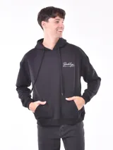 Buzo deportivo negro con capucha y cordones ajustables, bolsillo tipo canguro y puños y cintura acanalados. Estampado en el pecho con la palabra "Brooklyn" en cursiva y tipografía manuscrita.