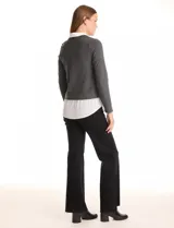 Buzo de tejido fino color gris oscuro con cuello en V, combinado con una camisa blanca que asoma por debajo, simulando un look de dos piezas.