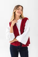 Chaleco negro de punto con diseño trenzado, escote en V y cierre frontal con botones.