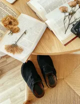 Suecos marrones de gamuza con hebilla lateral ajustable y suela de goma negra.