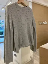 Sweater gris de punto calado con diseño de hojas, cuello redondo y corte holgado.