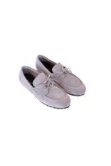Mocasín de cuero gamuzado color gris con lazo frontal y detalle de pasacintas laterales. Suela flexible antideslizante.