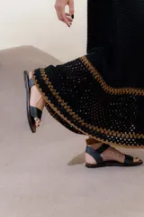 Vestido largo negro de punto con breteles finos y detalle calado en el ruedo.