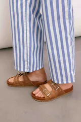 Pantalón celeste y blanco a rayas verticales, de tiro medio, corte recto y bolsillos traseros.