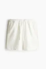 Short blanco de lino y algodón, con corte relajado, cintura elástica con cordón ajustable, bolsillos laterales y bolsillo trasero insertado.