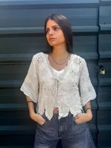 Camisa negra con detalles de crochet color crema, escote en V y mangas 3/4.