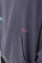 Canguro azul con capucha, bolsillo tipo canguro y puños y cintura acanalados. Estampado pequeño en el pecho con el texto "PULAU EST. 2023 MVD UY".