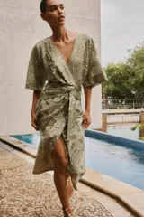 Vestido midi color verde oliva con estampado floral, escote en V, manga corta amplia y detalle drapeado en la cintura.