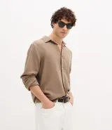 Camisa de hombre color verde menta, confeccionada en algodón texturizado con patrón melange. Presenta cuello inglés, manga larga y abotonado frontal. El corte es de estilo comfort, más generoso en sus medidas para mayor comodidad.