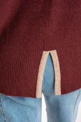 Sweater negro de tejido grueso con cuello alto acanalado. Presenta una franja decorativa en las mangas y el cuello en hilo marrón con brillo (lurex).