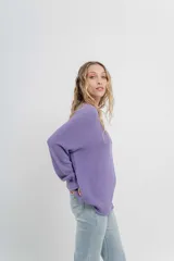 Sweater azul de punto medio, amplio, suave, con escote a la base y puños en mangas y en acabado inferior.