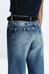 Pantalón de jean azul de corte culotte, tiro alto, pernera ancha y corta. Incluye cinturón marrón de gamuza con hebilla metálica.