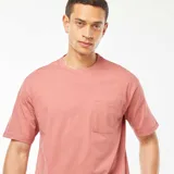 Camiseta color salmón de corte recto, manga corta con dobladillo y bolsillo en el pecho.