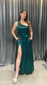 Vestido largo de fiesta color verde esmeralda brillante, de un solo hombro, con abertura en la pierna izquierda.