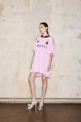 Vestido camiseta oversize de manga corta color rosa con cuello negro. Estampado frontal con logos de ESQUINA en negro. En la espalda, la inscripción "D10SA" en pedrería.