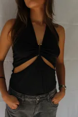 Body negro con escote halter, abertura en el abdomen y espalda descubierta.