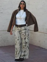 Campera bomber oversize color chocolate, con cierre frontal y detalles de ojales metálicos en la solapa. Confeccionada en gamuza, tiene mangas abullonadas con puños elásticos.