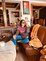 Sweater de punto grueso color gris con guarda pampa en tonos fucsia y blanco en el canesú.