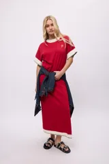 Vestido midi rojo de algodón con cuello redondo y mangas cortas con ribete blanco. Presenta un pequeño bordado en el pecho y ribete blanco en el ruedo.