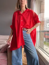 Camisa roja de algodón con bordado calado, corte amplio, cuello camisero y cierre frontal con botones.