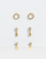 Set de tres pares de aros dorados con strass. Incluye un par de aros pasantes con forma circular, un par con dije de rombo y un par con dije de corazón.