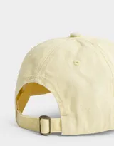 Gorra amarilla de gabardina con bordado de cerezas blancas en el frente y hebilla metálica ajustable en la parte posterior.