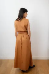 Conjunto color terracota compuesto por un chaleco sin mangas con cierre frontal y bolsillos utilitarios, y una falda larga de corte amplio y cintura alta con bolsillos laterales.