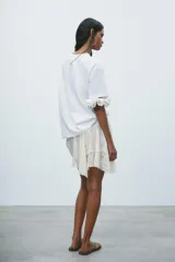 Camiseta blanca de corte recto y manga corta, con cuello redondo. Estampado frontal con dos mujeres en la playa y texto "Beach Days Best Days".