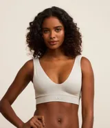 Soutien top deportivo color gris claro, confeccionado en poliamida con acabado seamless, breteles anchos fijos, escote en V y etiqueta Lov.