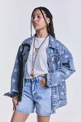 Campera de jean celeste con lavado ácido y estampado de estrellas blancas. Es de corte oversize.