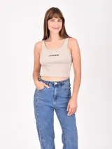 Musculosa corta marrón de morley con breteles finos y estampado de una estrella blanca en el centro.