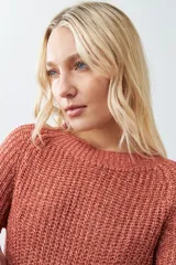Sweater rojo de tejido de punto con ruedo curvo y mangas 3/4.