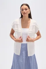 Poncho color marfil con diseño de flecos horizontales y cuello redondo.