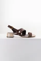 Sandalias de cuero color marrón con tiras cruzadas y hebilla dorada.