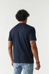 Remera blanca de algodón con estampado frontal de texto en azul y naranja. Corte clásico y cuello redondo.