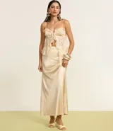 Blusa corta color crema, con lentejuelas y escote corazón. Tiene breteles finos ajustables, lazo en el busto y volados de chiffon.