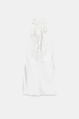 Vestido corto blanco de satén con cuello halter y espalda descubierta.