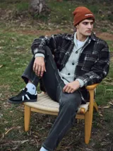 Sobrecamisa de hombre de manga larga con cierre de botones, bolsillos en el pecho y corte relajado. Confeccionada en tejido de peluche (Teddy) a cuadros en tonos marrón, gris y blanco.