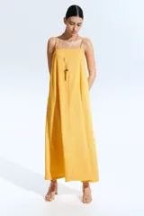Vestido midi amarillo con textura arrugada, breteles finos y escote recto.