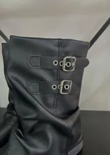 Botas de caña baja color negro con hebillas plateadas y efecto arrugado en el empeine.