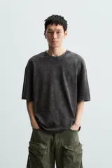 Camiseta azul marino de corte holgado, confeccionada en algodón con cuello redondo y mangas cortas. Presenta un efecto de lavado que le da una apariencia única.