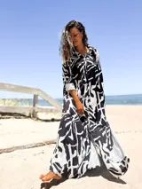 Vestido camisero largo con estampado abstracto en blanco y negro, cuello camisero, mangas 3/4 con puños y bolsillos laterales.