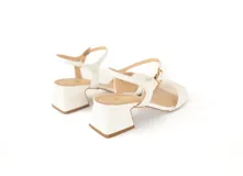 Sandalias de cuero color blanco, con taco cuadrado y pulsera al tobillo.