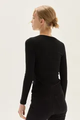 Top de manga larga color beige, confeccionado en tela de lurex, con calce al cuerpo y escote cuadrado.