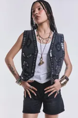 Chaleco negro de jean con bordados y apliques plateados.