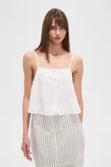 Musculosa blanca de algodón con breteles finos, bordado calado y botones frontales.