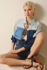 Camisa de mangas largas confeccionada en tencel de distintos tonos de azul, con costuras a contratono. Tiene cuello camisero, bolsillos con solapa en el frente y bolsillos ojal en los laterales.