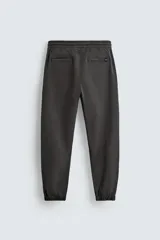 Pantalón jogger negro de corte slim fit, confeccionado en tejido de algodón con cintura elástica ajustable con cordón, bolsillos frontales y traseros de vivo, y bajo con puño elástico.