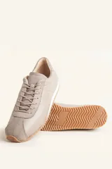 Zapatillas deportivas de cuero color borgoña con detalles en gamuza al tono, cordones finos y suela de goma blanca.