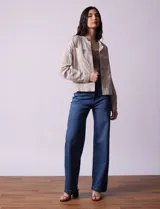 Chaqueta color beige de lino y rayón, con cuello mao, cierre frontal con botones y bolsillos delanteros.
